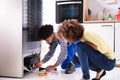 Technician Examining Refrigerator With Digital Multimeter