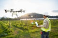 Technician farmer use wifi computer control agriculture drone fly to sprayed fertilizer on grape field, Smart farm concept