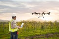 Technician farmer use wifi computer control agriculture drone fly to sprayed fertilizer on grape field, Smart farm concept Royalty Free Stock Photo