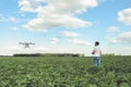 Technician farmer use wifi computer control agriculture drone on green field