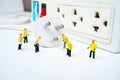 Technician figurine maintenance team try to plug switch of electricity
