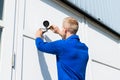 Technician Fixing Camera On Wall