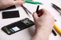 Technician fixing mobile phone at table. Device repair service Royalty Free Stock Photo