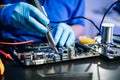 Technician in gloves performs precise soldering on circuit board using hot air gun. Concept of electronics repair Royalty Free Stock Photo