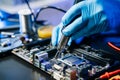 Technician in gloves performs precise soldering on circuit board using hot air gun. Concept of electronics repair Royalty Free Stock Photo