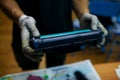 Technician hand cleaning printer toner cartridge. used laser toner cartridge.