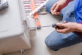 Technician hand using screwdriver to outdoor unit of air conditi