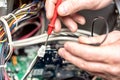 Technician hands with voltmeter above computer motherboard. Repair of computers concept. Toned with selective focus Royalty Free Stock Photo