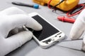 Technician hands working on broken smartphone for repair or replace new part on desk Royalty Free Stock Photo