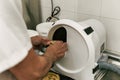 Technician inserting a dental plaster cast into a trimmer