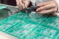 Technician inserting electronic components into a PDB for assembly