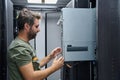 IT technician inspecting and installing server hardware inside a data center equipment rack Royalty Free Stock Photo