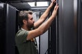 IT technician inspecting server rack in data center performing maintenance and hardware installation Royalty Free Stock Photo