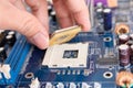 Technician installing CPU chip microprocessor to socket on motherboard