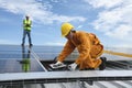 Technician Installing Equipment and Wiring Connect in System of Photovoltaic Installation on Factory Roof Buildings with Engineer