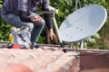 Technician installing satellite dish and television antenna on roof top Royalty Free Stock Photo