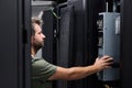 IT technician installing server hardware in a data center rack performing maintenance and inspection Royalty Free Stock Photo