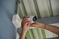 Technician installing wireless CCTV camera by screwed for home security system and installed w Royalty Free Stock Photo