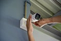 Technician installing wireless CCTV camera by screwed for home security system and installed w Royalty Free Stock Photo
