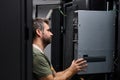 IT technician installing server hardware in a data center server rack performing maintenance and equipment check Royalty Free Stock Photo