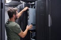 IT technician installing server hardware in a data center rack performing maintenance and configuration Royalty Free Stock Photo
