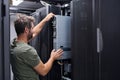 Server technician installing a rack server in a modern data center performing IT maintenance and hardware upgrade Royalty Free Stock Photo