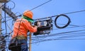 Technician on ladder is Repairing Fiber Optic Cable in Internet Splitter Box on Electric Pole against blue sky Royalty Free Stock Photo