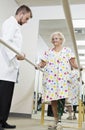 Technician looking at senior woman having ambulatory therapy