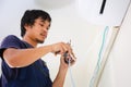 Technician man installing air conditioning in a client house, Electrician mounting the wires into air conditioning unit, Repairman Royalty Free Stock Photo