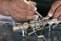 The technician man is repairing the vintage style saxophone instrument.