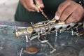 The technician man is repairing the vintage style saxophone instrument.