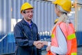 Technician man and woman shake hand together in front of cargo container with concept of successful in shipping business Royalty Free Stock Photo
