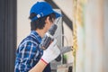 Technician man in work gloves holding an electric screwdriver, Repair and maintenance concepts