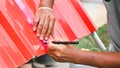 The technician measures the length of the metal sheet with a measuring ruler and writes the distance with a pen marker