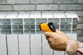 Technician measures the temperature of the heater radiator. Royalty Free Stock Photo