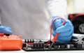 Technician measuring voltage of in computer mainboard using electronic digital multimeter Royalty Free Stock Photo