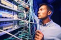 Technician monitoring fiber optic cables with electronic device