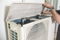 A technician opens up the top hatch of the outdoor compressor unit of a Split type air conditioner. Repair or maintenance work Royalty Free Stock Photo