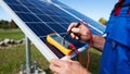 Technician working on solar panel, using a multimeter to check the voltage and ensuring efficient operation of the renewable Royalty Free Stock Photo