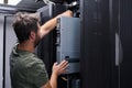 It technician performing server maintenance in a data center rack handling hardware installation and repair Royalty Free Stock Photo
