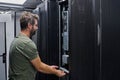 IT technician performing server maintenance in a data center rack during routine equipment inspection Royalty Free Stock Photo