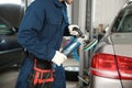 Technician polishing car body with tool at automobile repair shop Royalty Free Stock Photo