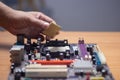 Technician preparing to assemble CPU into motherboard