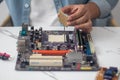 Technician preparing to assemble CPU into motherboard