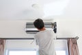 Technician preparing to installs new air conditioner on white wall in the room