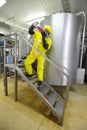 Technician in protective coveralls with sample of fluid