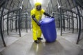 Technician in protective uniform with barrel