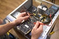 Technician repairing a broken computer in a workshop, close-up Royalty Free Stock Photo