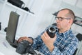 Technician repairing broken digital camera lense in workshop Royalty Free Stock Photo