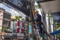 A technician is repairing or checking the messy electrical network in the city of Hanoi